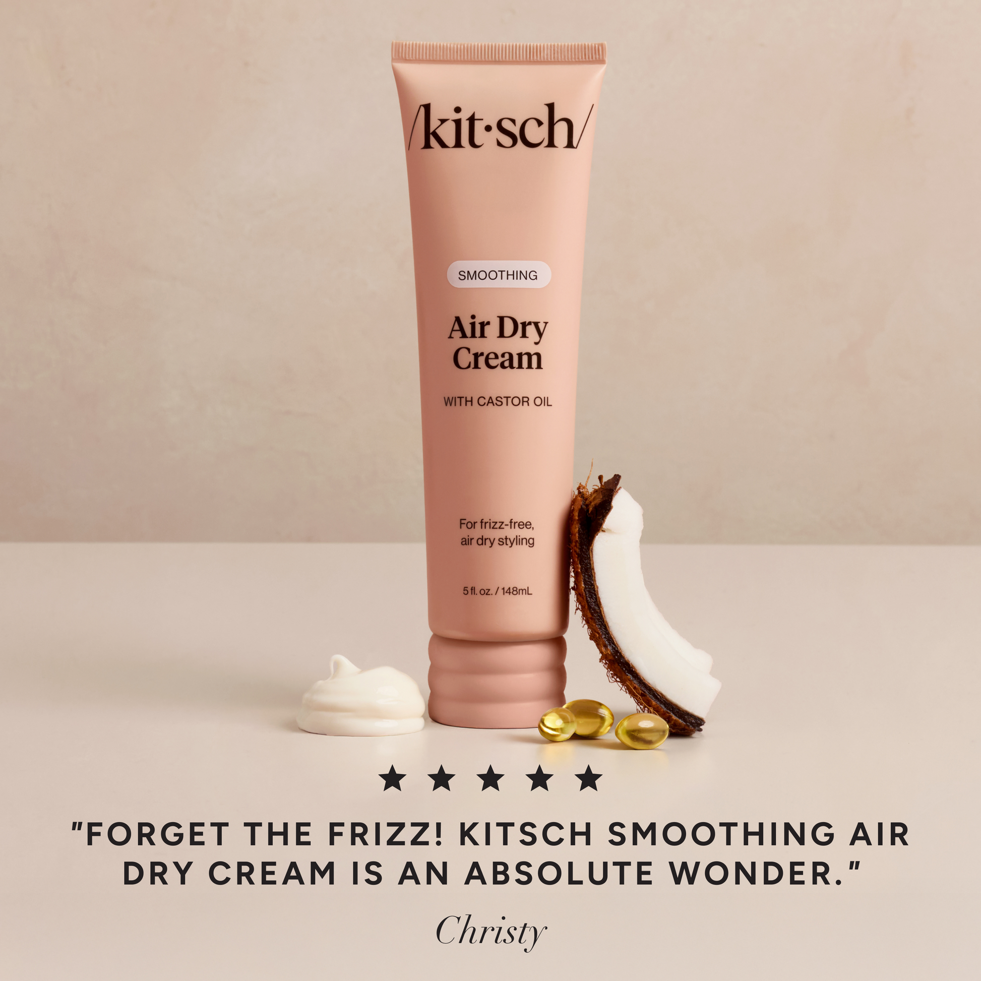 KITSCH Smoothing Air Dry Cream squeeze bottle on a creamy backdrop, showcasing the soft Kitsch Pink minimalist packaging and product label