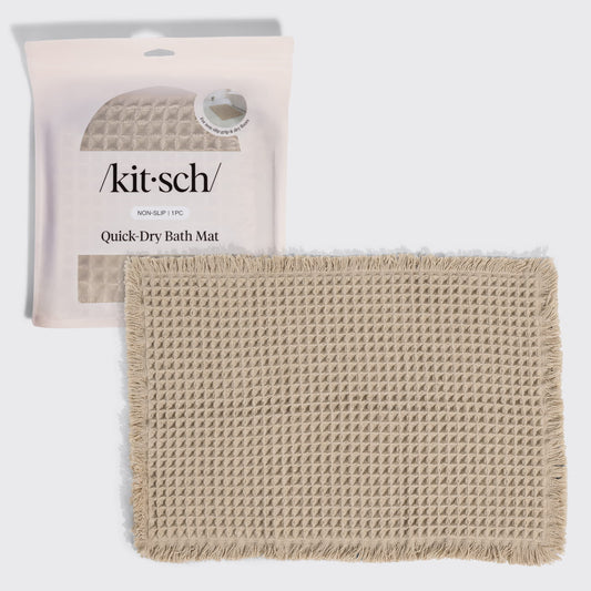 Kitsch Quick-Dry Bath Mat in camel hero image, shown with its retail packaging (non-slip, 1 piece) behind the folded mat.